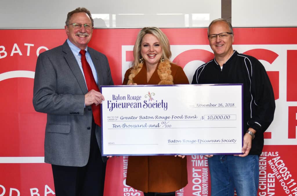 Two men and one woman with a large check.